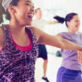 Group of people smiling while exercising in a workout studio