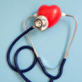 Stethoscope with red hear form sitting on blue background