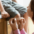 Person putting band-aid on child's knee