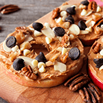 Apple slice with peanut butter, nuts and chocolate chips on top