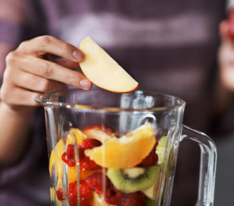 Closeup of person making a fruit smoothie in a blender