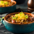 Bowl of chili with shredded cheese on top