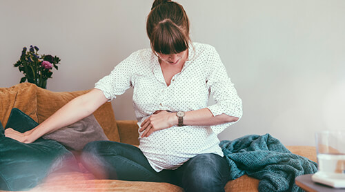 Pregnant person holding stomach during contraction