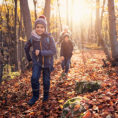 Children hiking in forest during fall