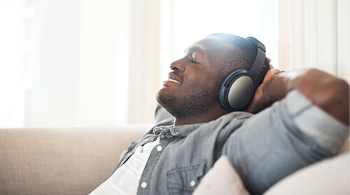 Relaxed man listening to music with headphones and eyes closed