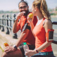 Two people eating snacks after a workout outdoors