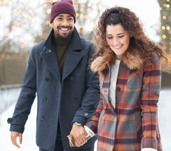 Couple holding hands while ice skating outdoors in the winter