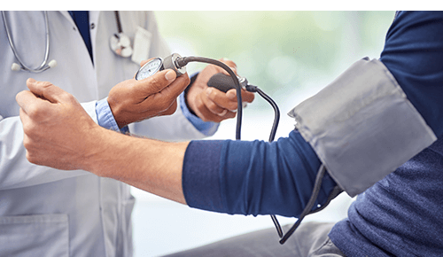 Doctor taking blood pressure using cuff on person's arm