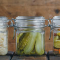 Three jars full of a variety of fermented vegetables and pickles