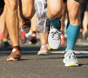 Closeup of a group's shoes as they run a race outdoors