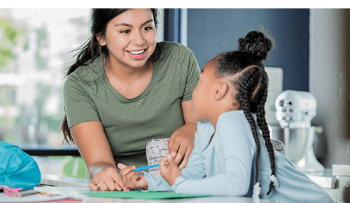 Young adult talking too a child while they color Young adult talking too a child while they color
