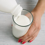 Pouring kefir from a bottle into a glass