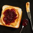 Piece of toasted bread topped with peanut butter and jam