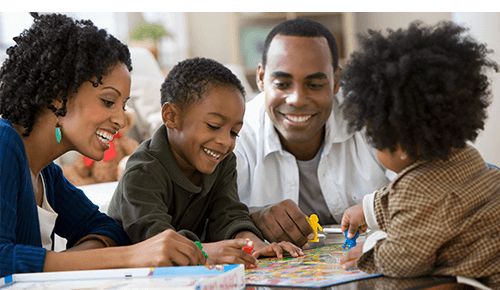 Family playing a board game together Family playing a board game together