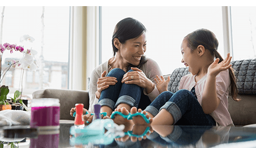 Mother and daughter painting their toenails on the couch Mother and daughter painting their toenails on the couch