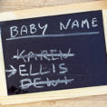 Chalkboard with baby names written on it, one name crossed out