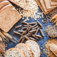 Variety of bread, grains and dry pasta on blue tabletop