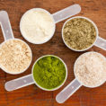 Variety of measuring cups filled with different protein powders