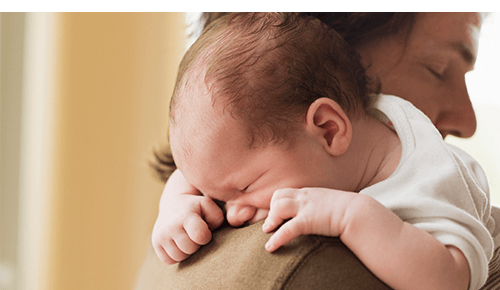 Parent holding baby over shoulder