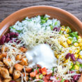 Bowl of rice with vegetables and sour cream topping