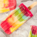 Rainbow colored popsicles sitting on ice