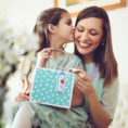 Daughter giving her mother a gift bag for Mother's Day