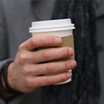 Closeup of person holding a carryout cup of coffee