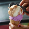Scooping two flavors of ice cream on to a cone