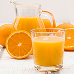 Glass pitcher and cup filled with orange juice