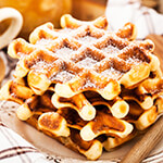 Stack of waffles with powdered sugar on top