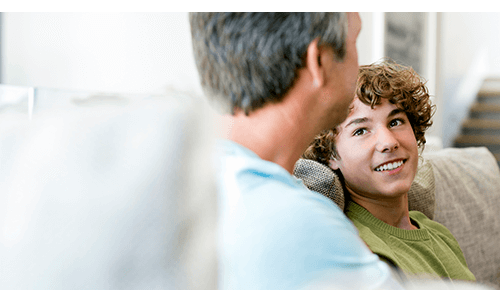 Father and son talking together on couch Father and son talking together on couch