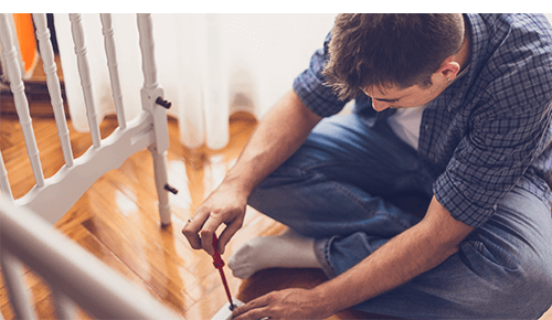 Person using tool to put together a baby crib Person using tool to put together a baby crib