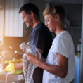 Father and child washing dishes together at a kitchen sink