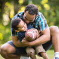 Father and son playing football outside