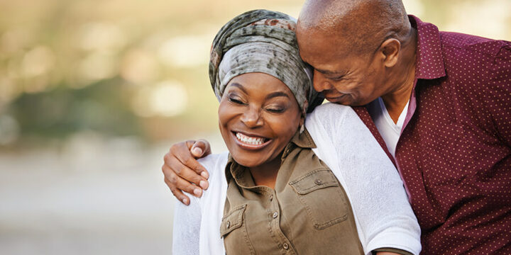 Couple smiling and embracing outside