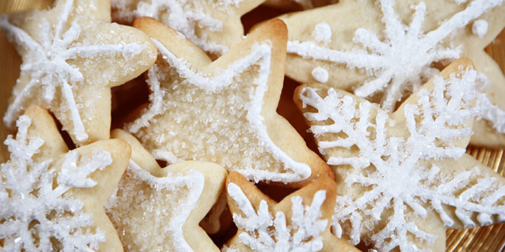 Closeup of sugar cookies in snowflake shapes with white frosting