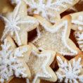 Closeup of sugar cookies in snowflake shapes with white frosting
