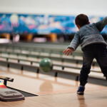 Child bowling at a bowling alley