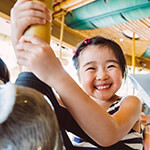 Young child smiling while riding on a carousel