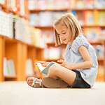 Child reading a book in a book store