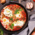 Cast iron pan filled with shakshuka and eggs