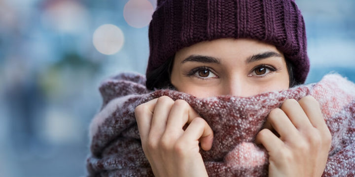 Woman bundled up with scarf and cold winter gear while standing outside