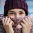 Woman bundled up with scarf and cold winter gear while standing outside