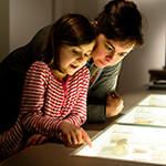 Parent and child looking at installation in museum