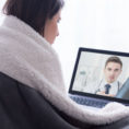 Sick person talking to doctor in a virtual meeting on her computer laptop