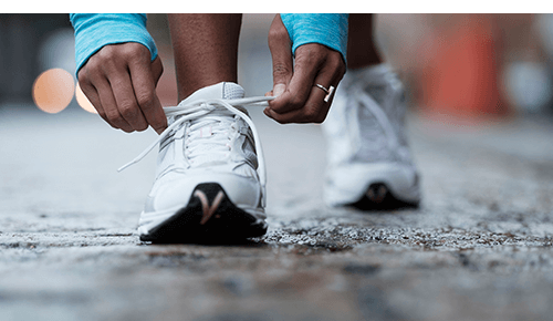 Closeup of person tying laces of athletic shoe Closeup of person tying laces of athletic shoe