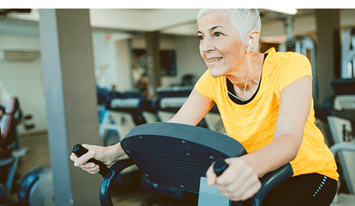 Person working out at gym on exercise machine Person working out at gym on exercise machine