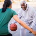 Two people playing basketball outside