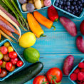 Variety of colorful fruit and vegetable sitting on blue wood background