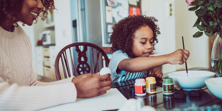 Parent and child doing crafts and painting at table